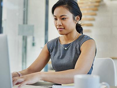 An online college student using a laptop in a business setting.